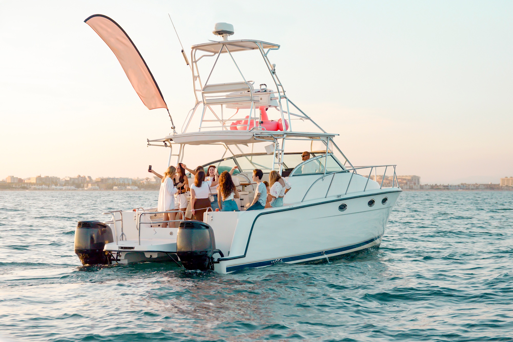 Youth party on vacation at sea. Girlfriends drink champagne, dance on the yacht